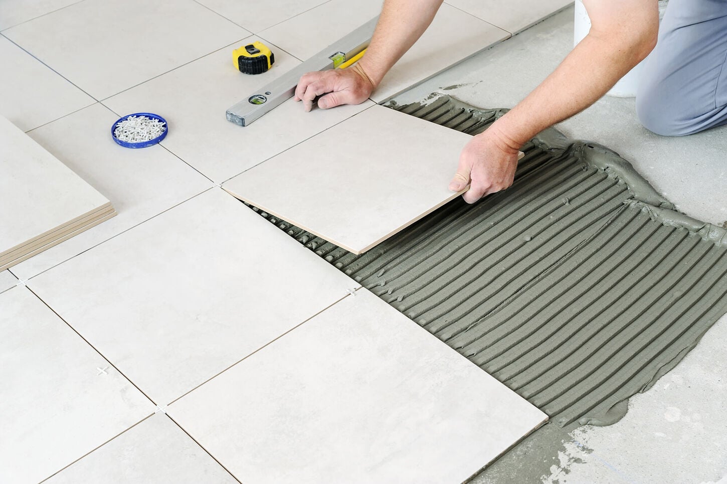 someone laying down tile in grout on the floor