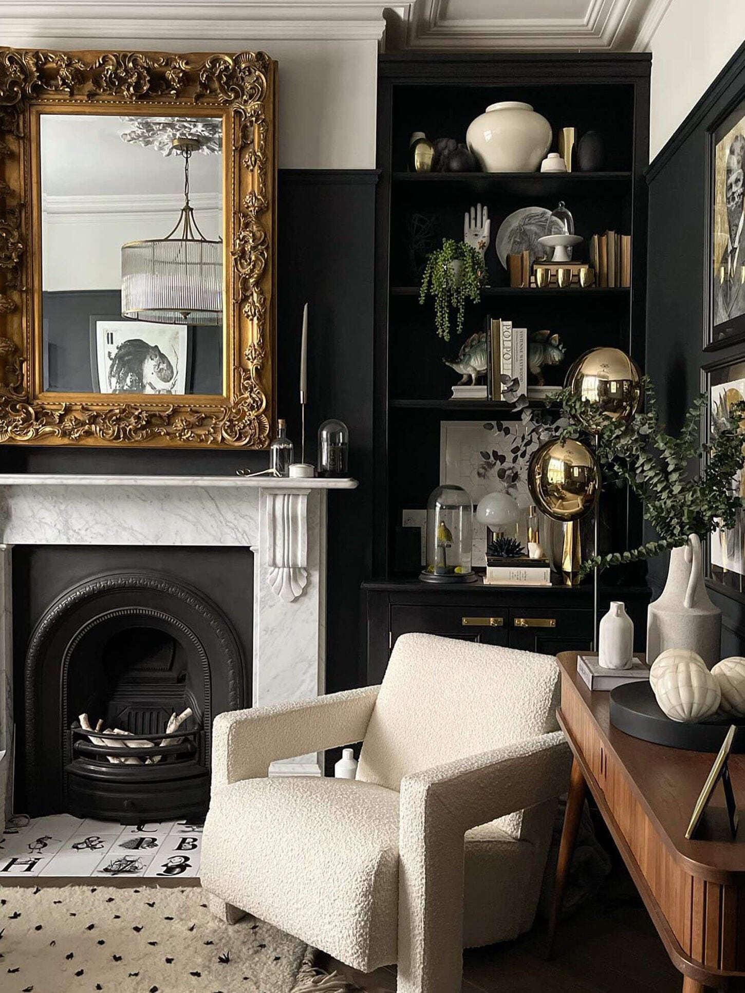 Mix of dark and light colors in a home office with a fireplace, chair, bookshelf and lots of hold and green decor