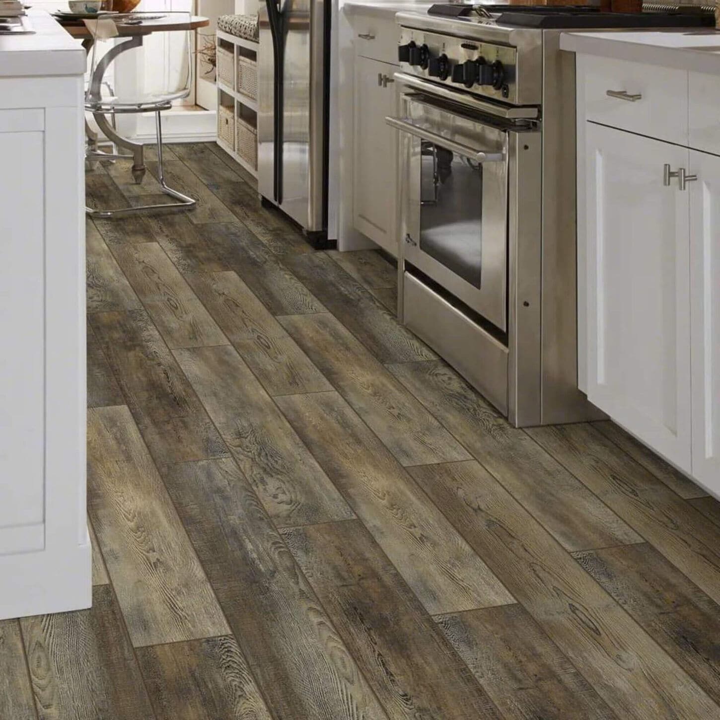 kitchen with white cabinets, stainless steel appliances, and a medium brown wood look vinyl floor