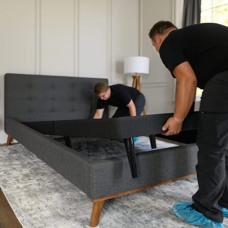 Delivery team placing base inside bed frame