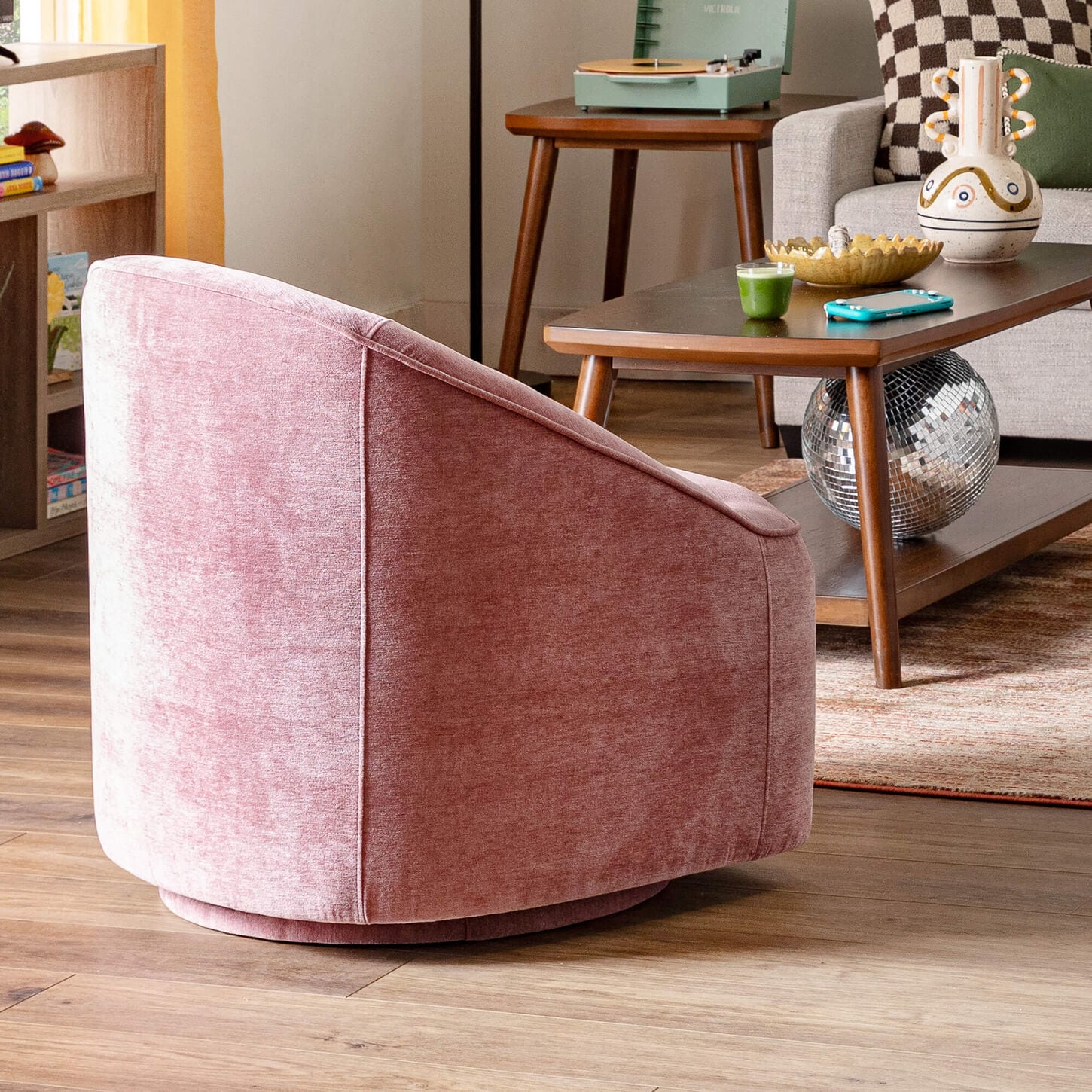 Pink accent chair in a dorm room with other furniture
