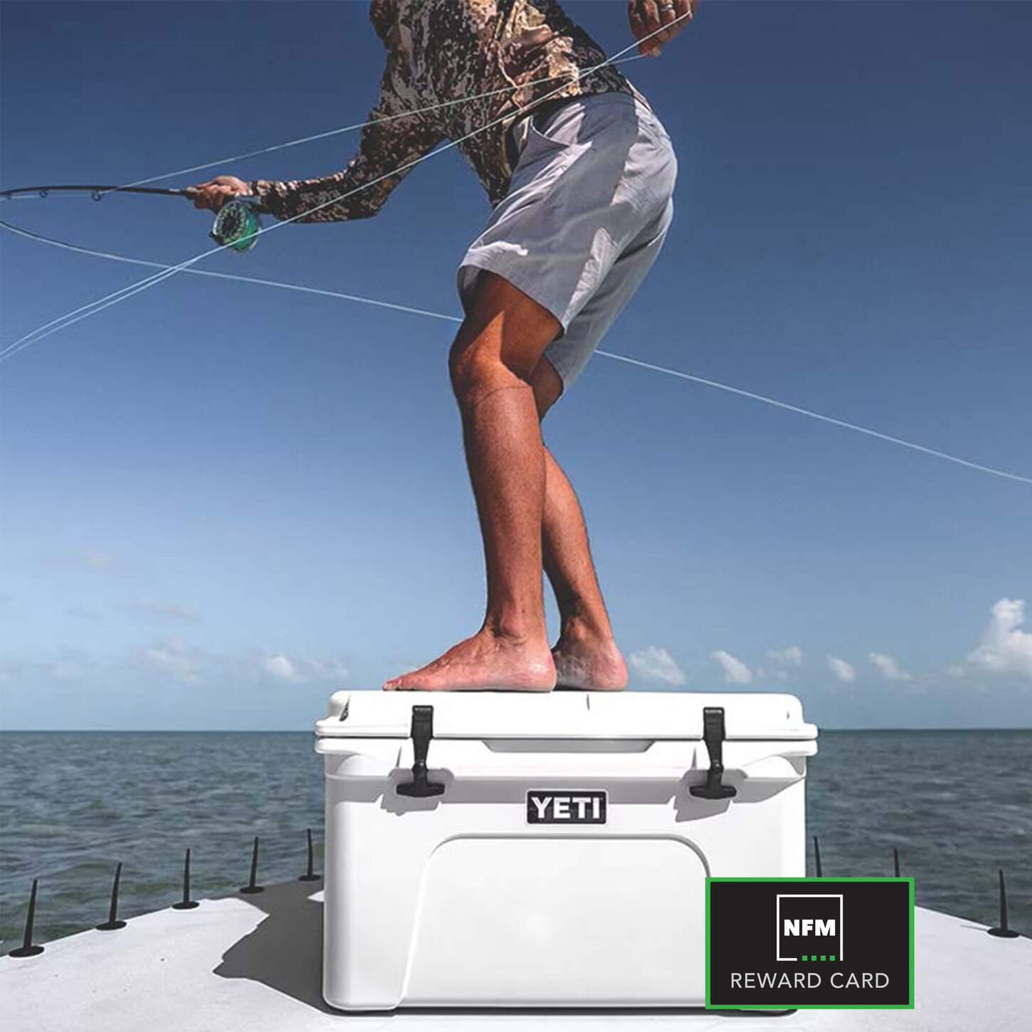 person standing on a white yeti cooler in the bow of a boat while fly fishing