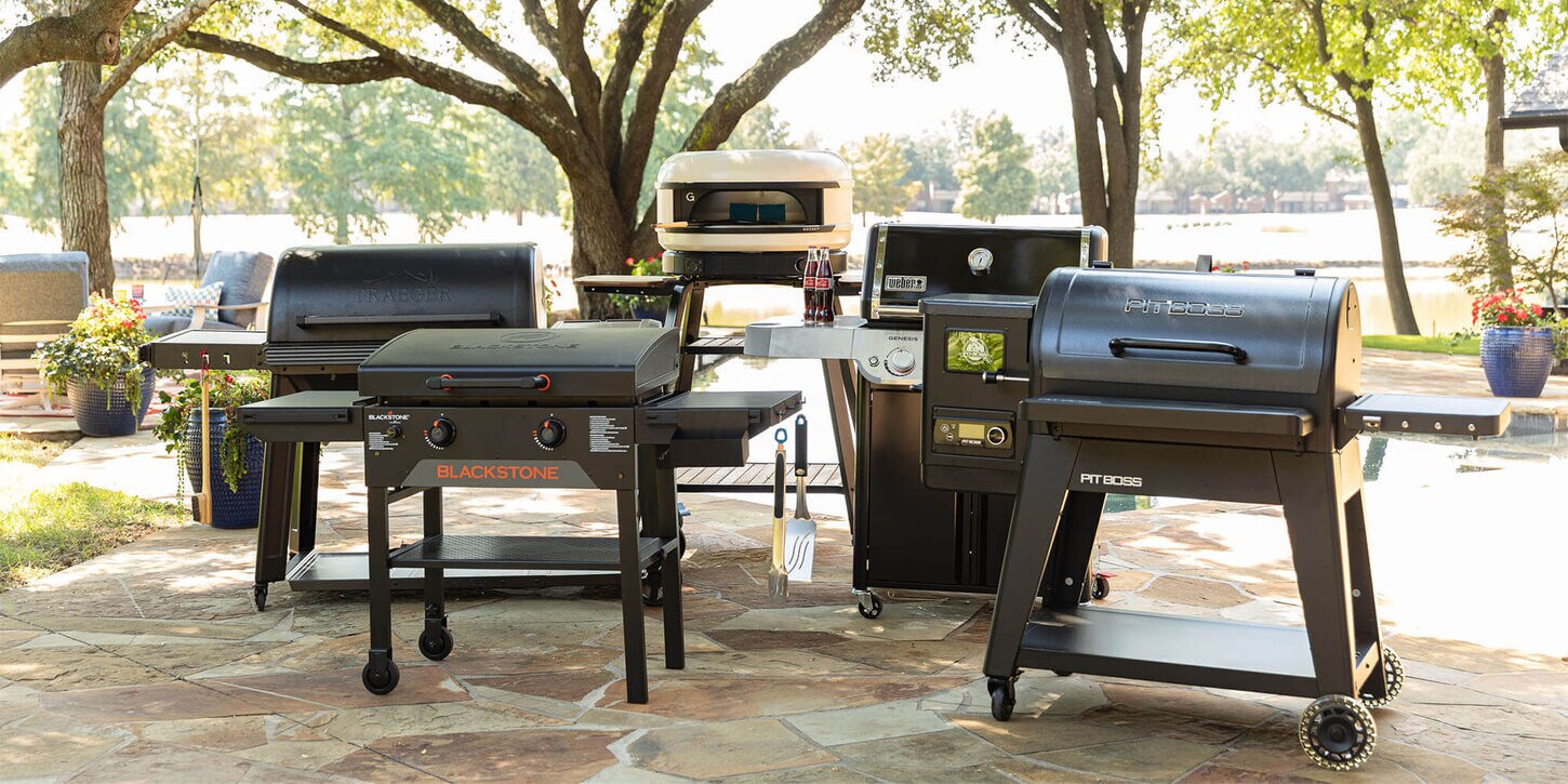 Various grills in a backyard featuring lots of different brands