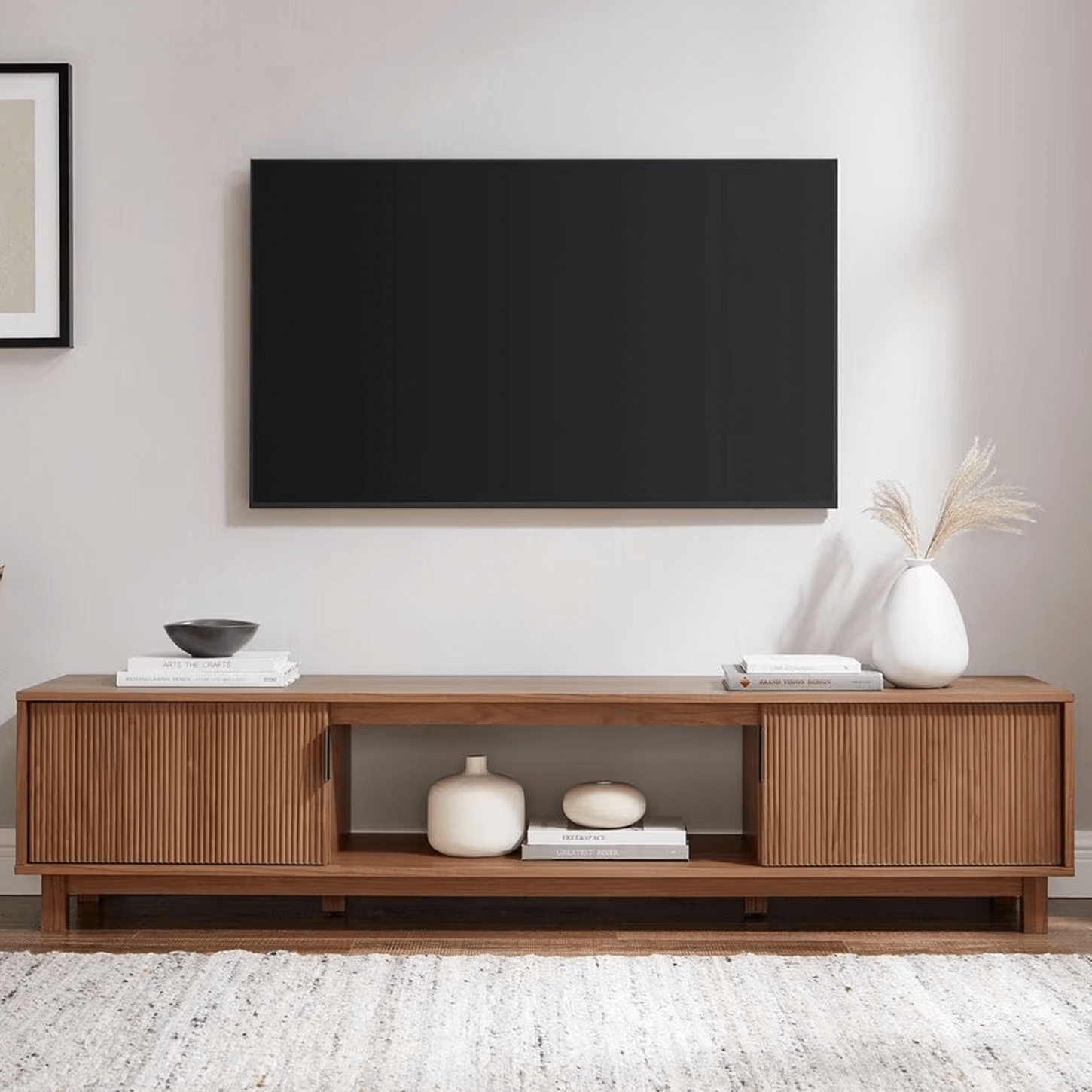 Medium wood TV stand with mounted TV and decor