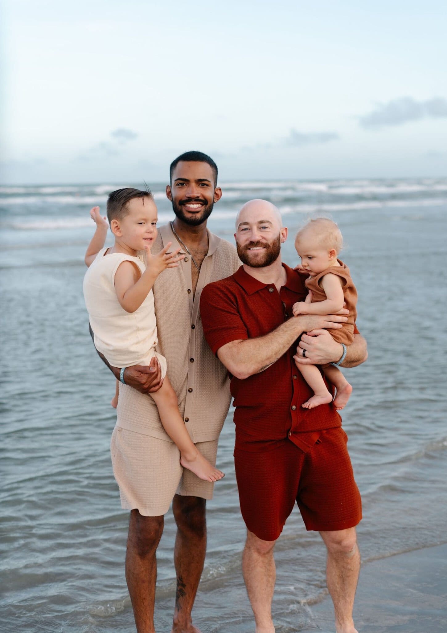 Jake with his husband and two children at the beach