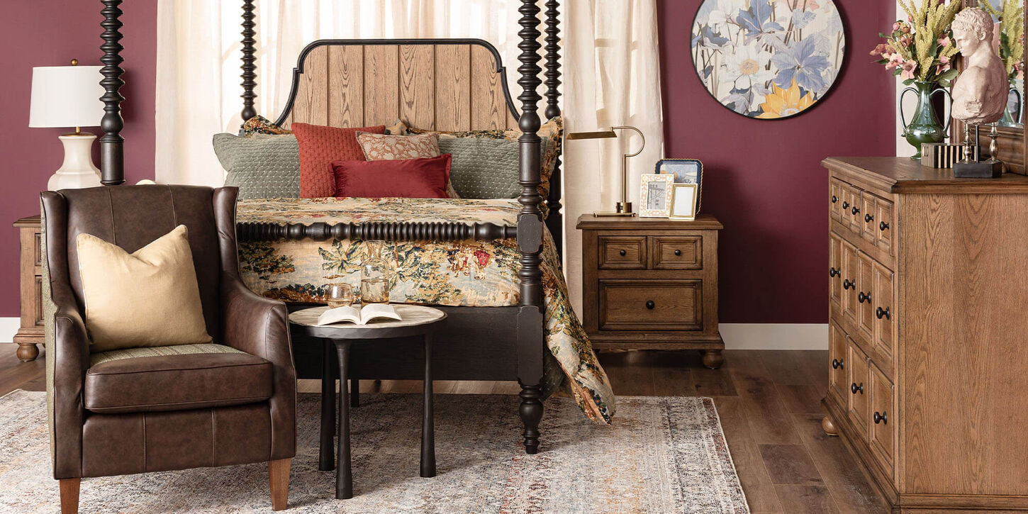 Bedroom with a bed, chair and table, nightstands, large rug, and dresser with home decor