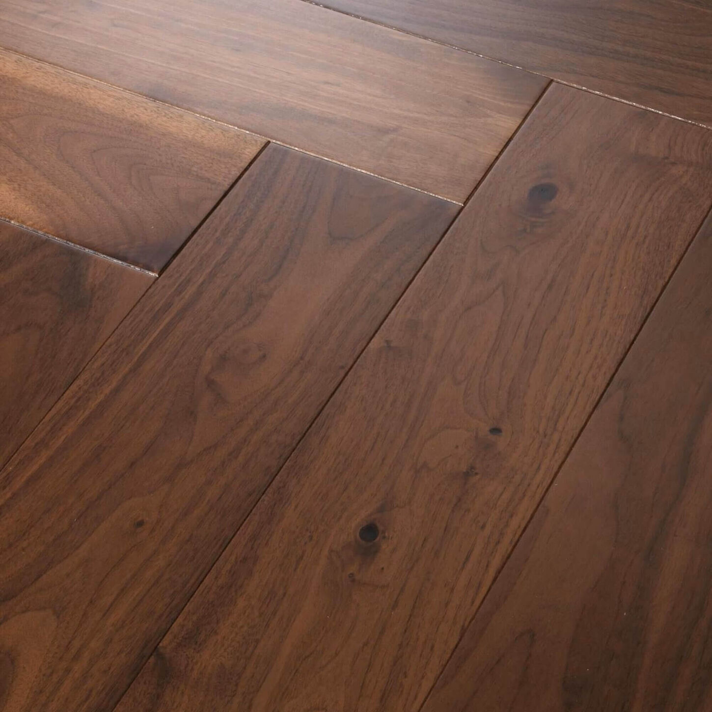 Man working on a laptoAnderson Tuftex Revival Walnut Herringbone Rye Engineered Hardwoodp at a table with his cup of coffee