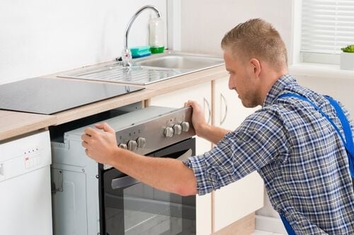 Man installing under counter dishwasher