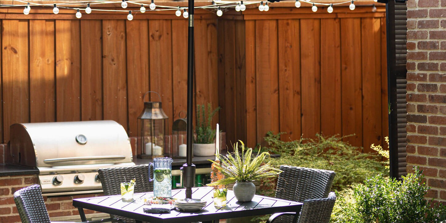 Backyard patio furniture and string lights hanging across the yard