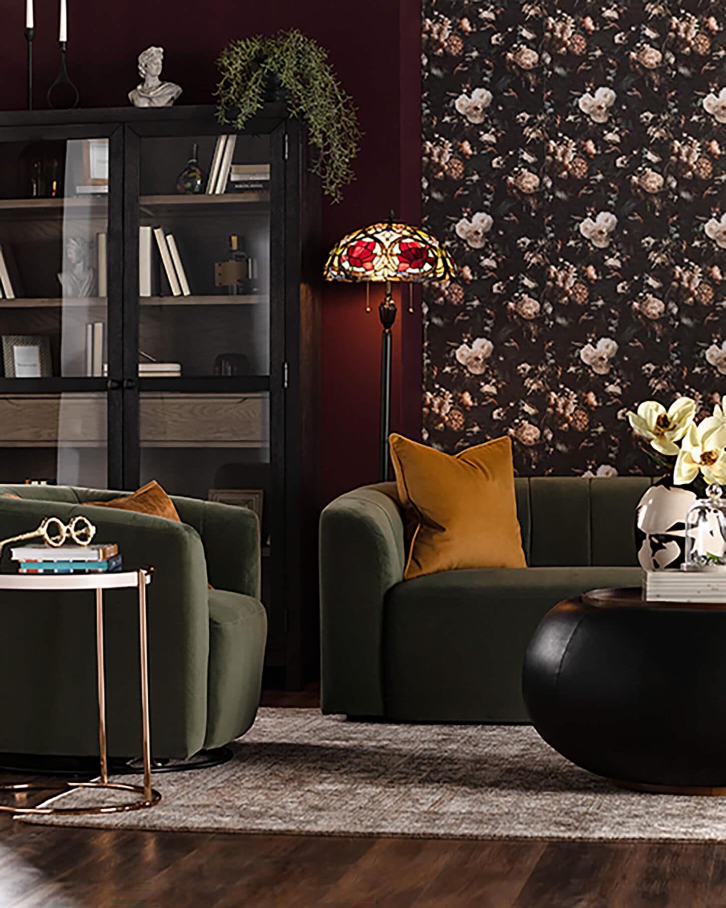 dark room showcasing the red and navy wallpaper with a green couch and mustard yellow pillow