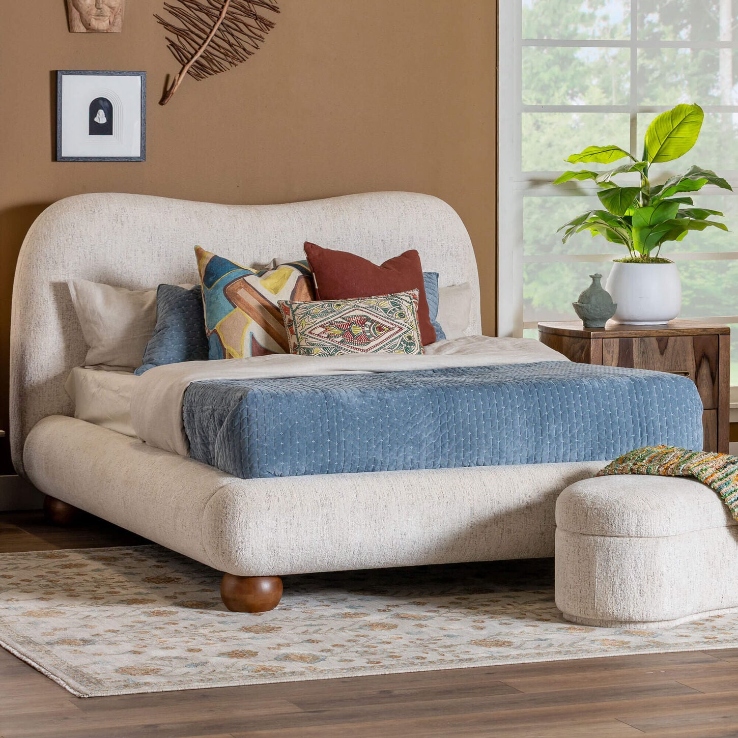 White upholstered bed with blue blanket