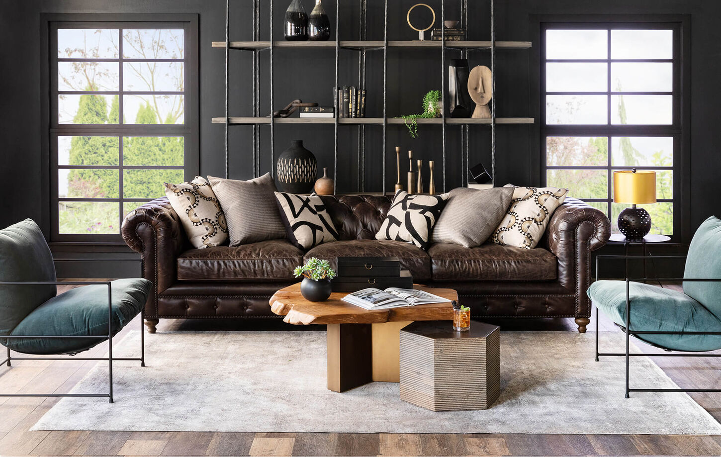 A well furnished living space with a green wall in the background and a circle mirror.