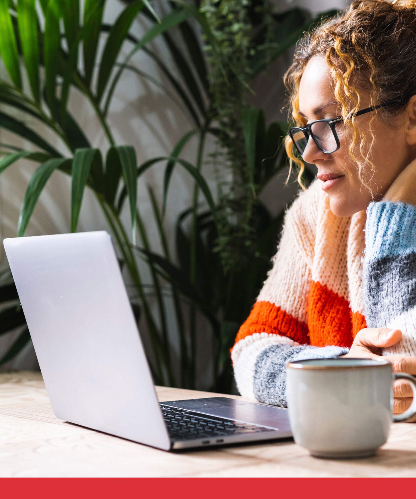 Young woman looking and reading on a laptop.