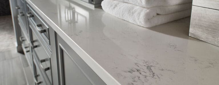 Quartz bathroom countertop with white folding towels on counter
