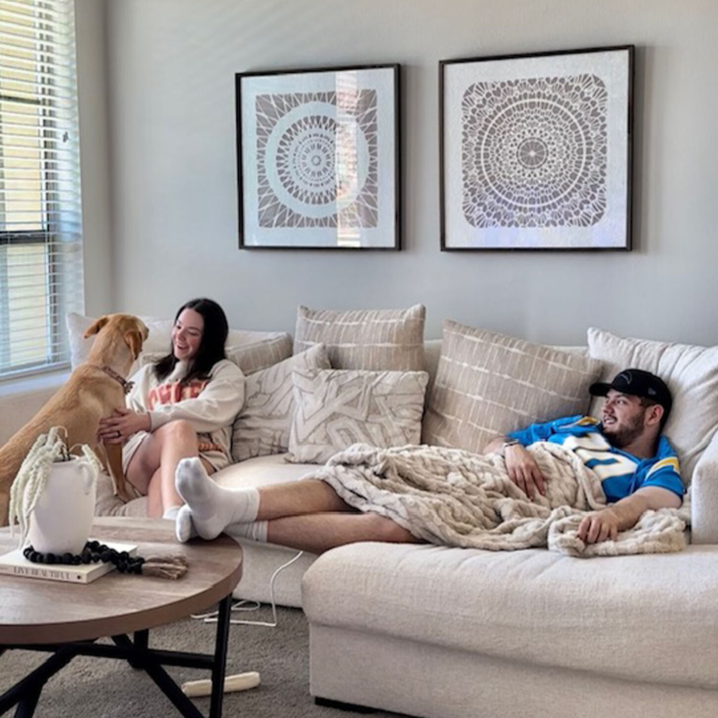 ashley and jonathan sitting at home on their couch with their dog