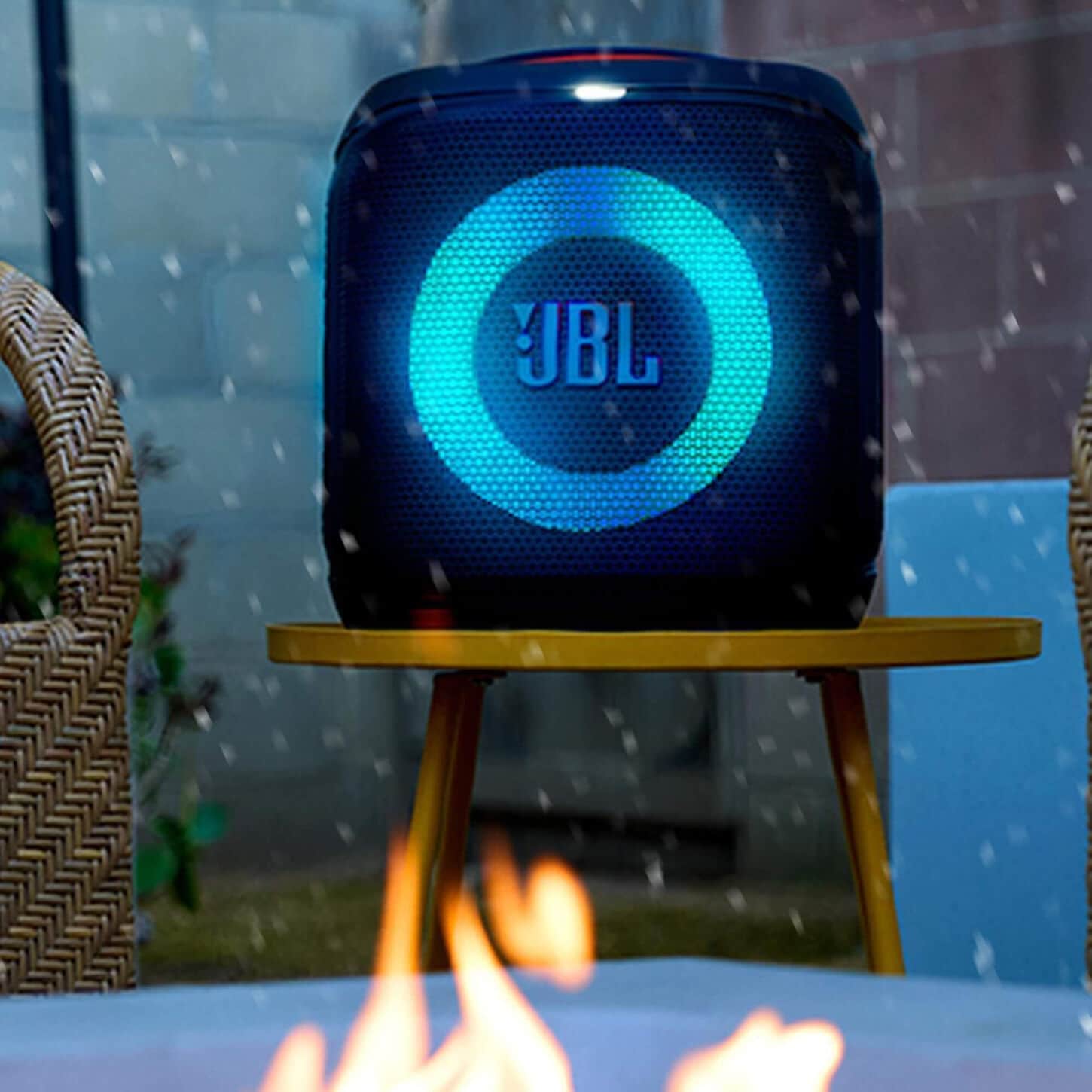 JBL party speaker sitting outside next to a firepit