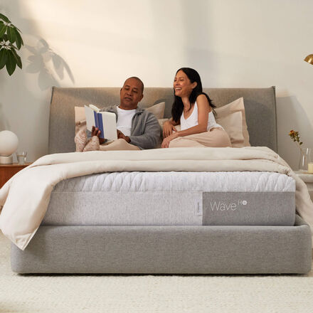 Couple relaxing on a mattress laughing at a book