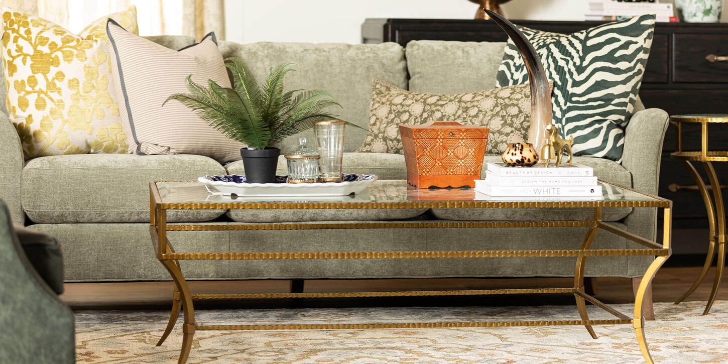 Living room sofa with large area rug, coffee table, and home decor