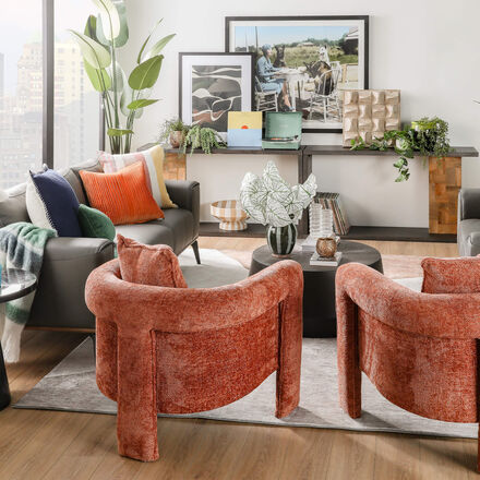 Mid-centruy modern interior designed room with velvet orange accent chairs