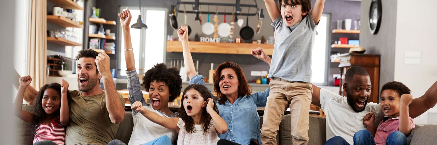 Family and friends cheering together in a home.