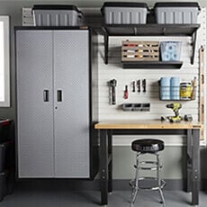 garage with wood top work bench and a grey and black wall cabinet