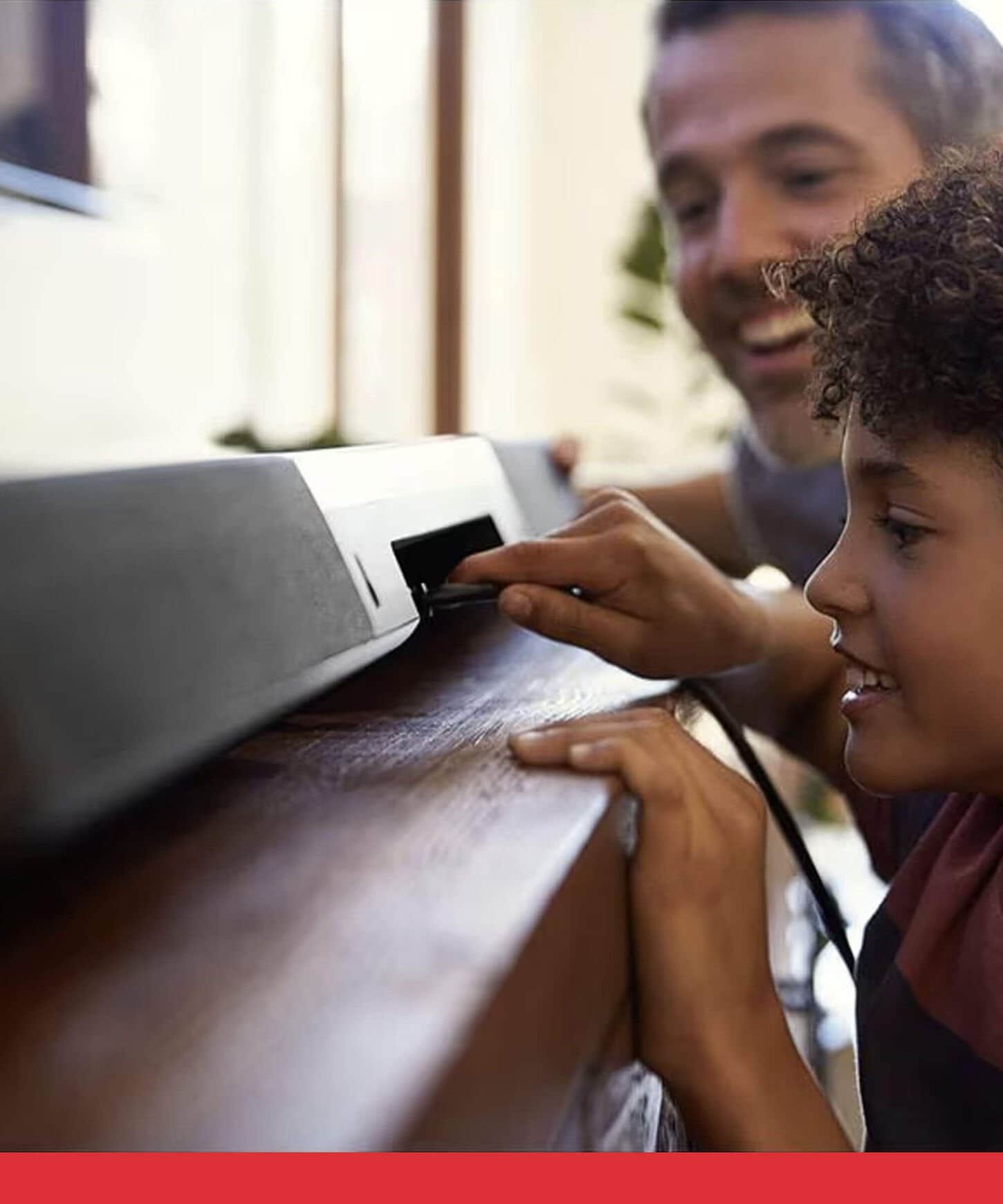 Father and son plugging in a new soundbar.