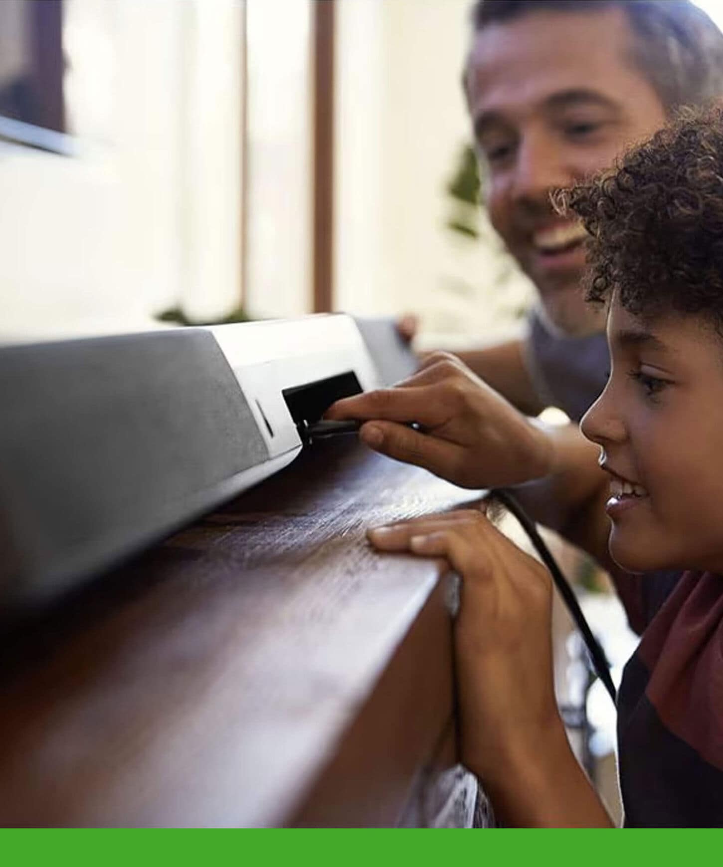 Father and son plugging in a new soundbar.