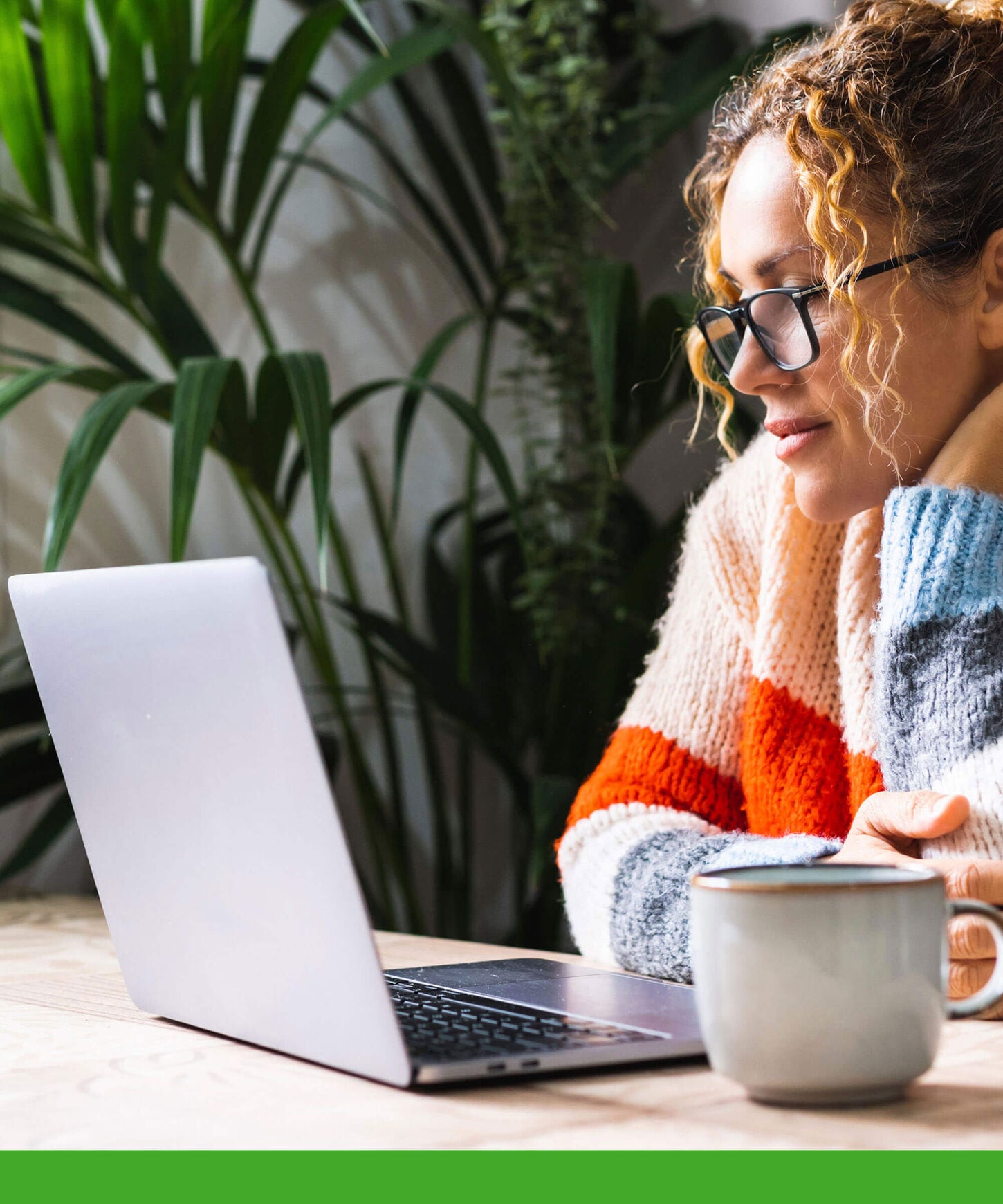 Young woman looking and reading on a laptop.