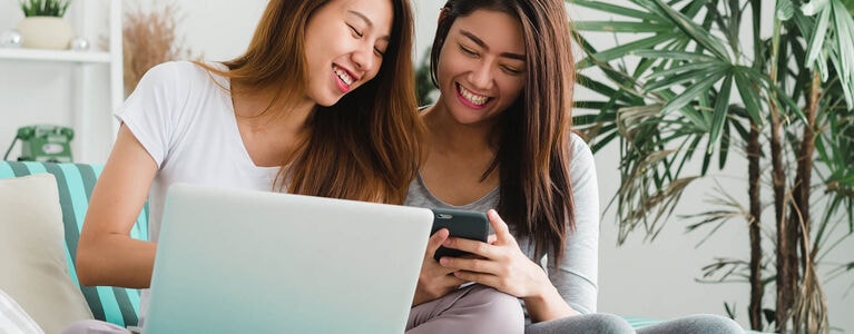 Friends shopping online using a laptop computer