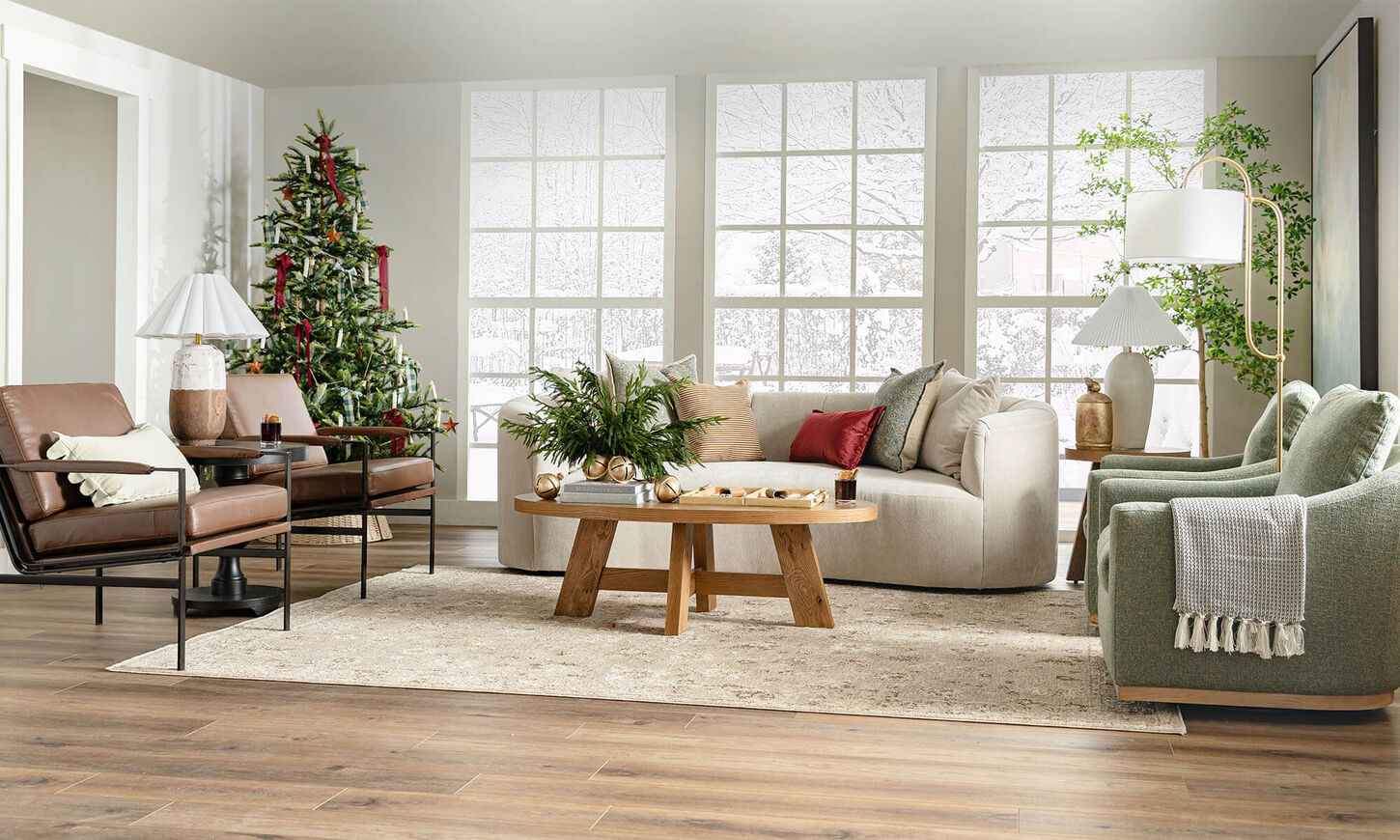 Living room with holiday décor, Christmas tree, beige sofa, green chairs, wood coffee table, and large windows.