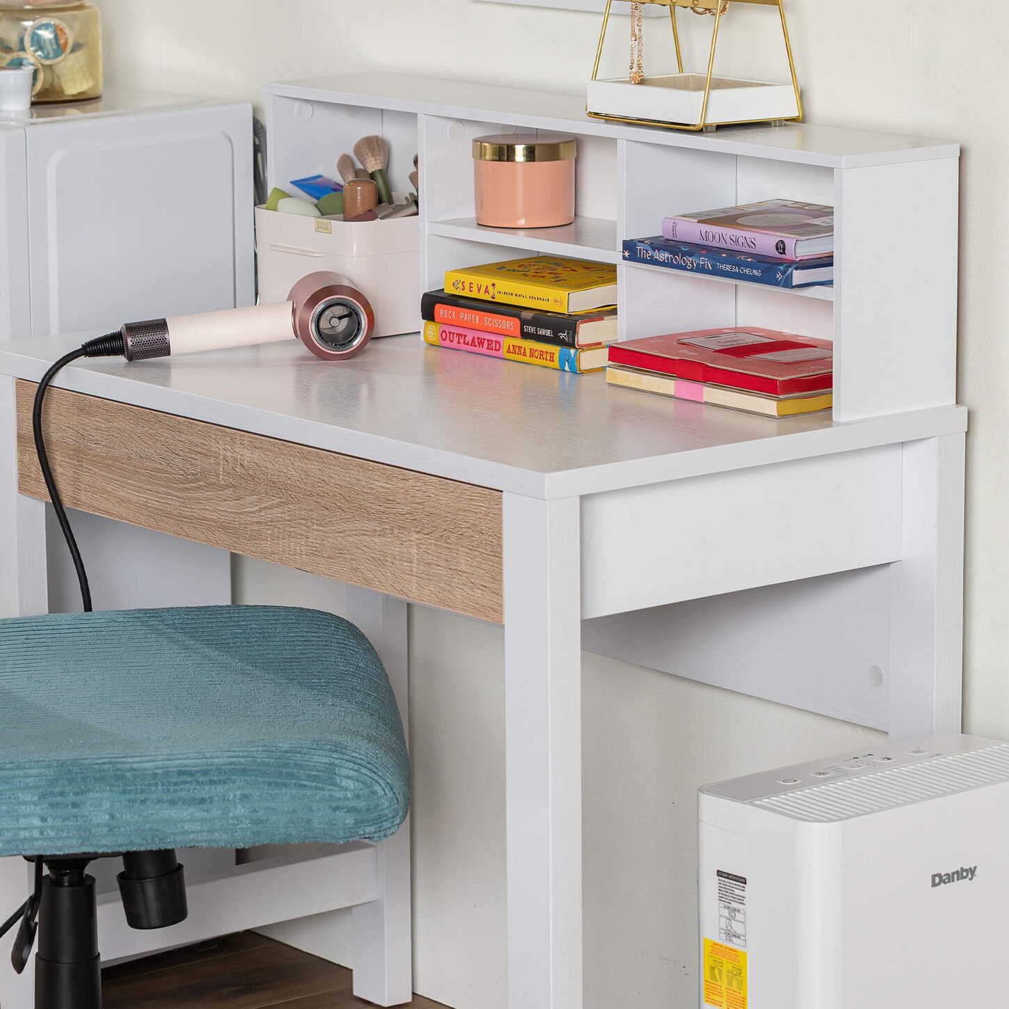 White desk with various books on top of it