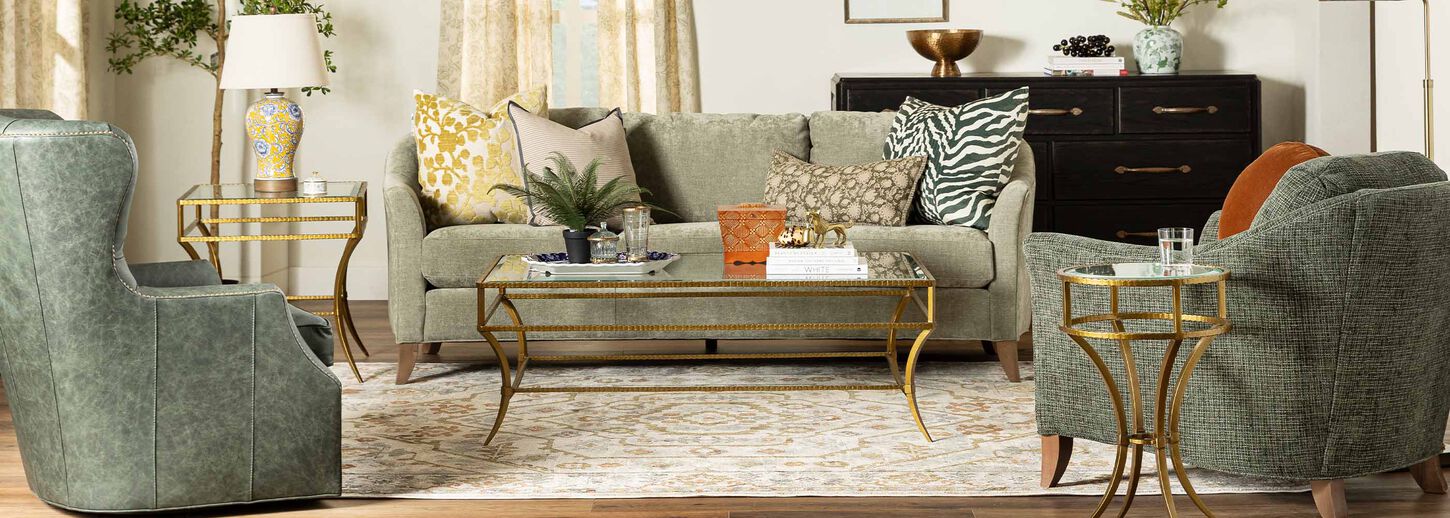Brightly lit living room with green sofa and chairs