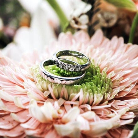 Pair of wedding bands staged laying on a flower