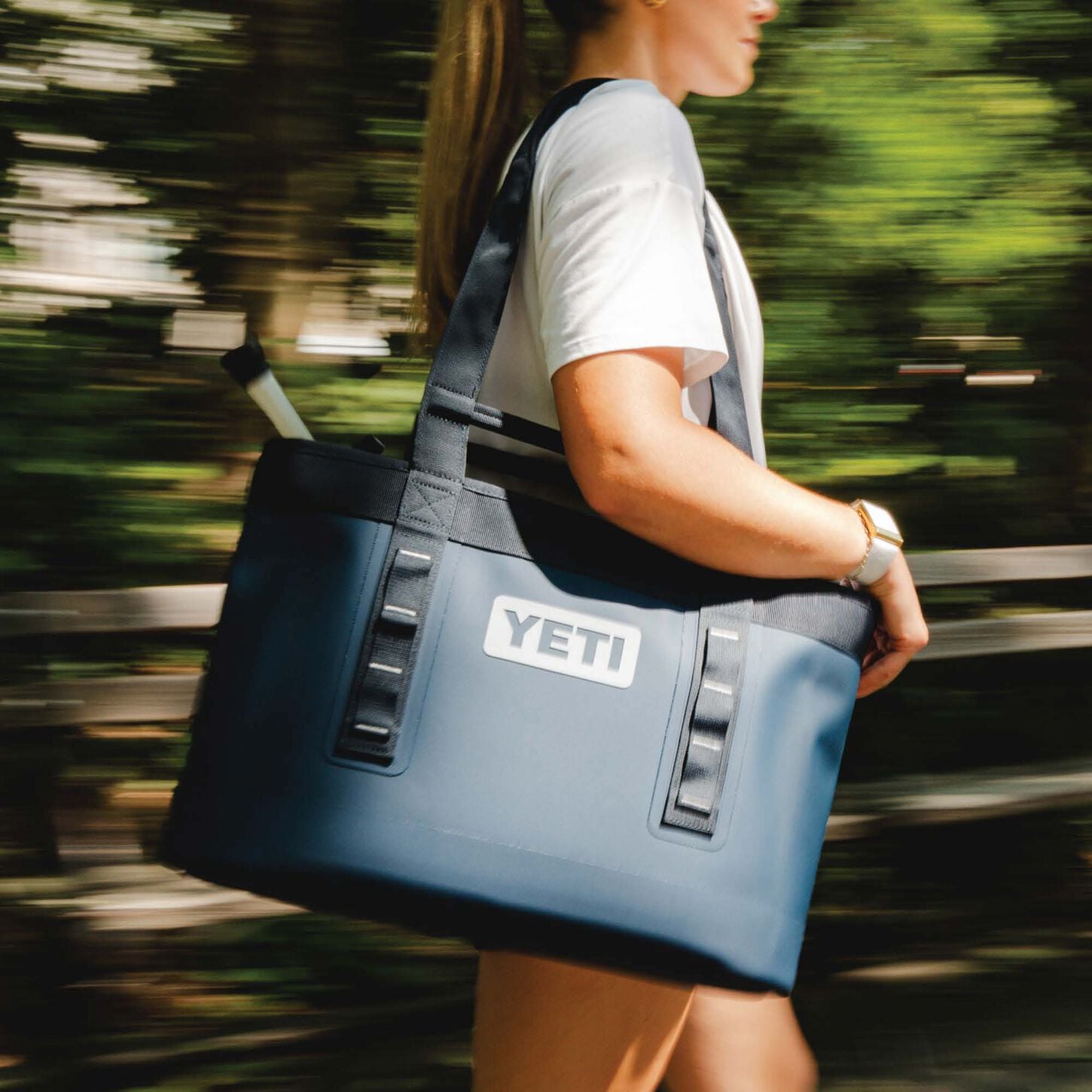 person carrying a blue yeti tote bag