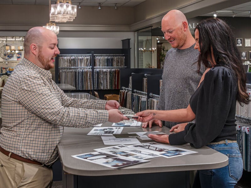 Couple meeting with designer at consultation looking at plans