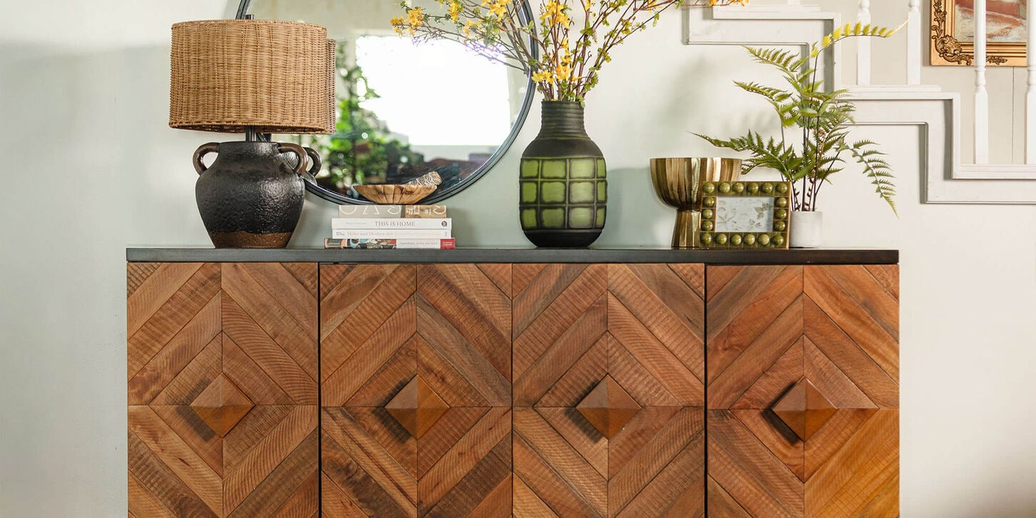 Entryway table with lamp, lots of vases, and mirror