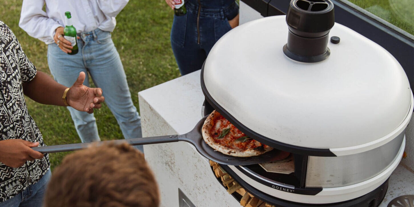 Group of people gathered around a pizza oven