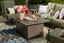 Green covered patio furniture with extra seating and a table set up with wine and flowers.