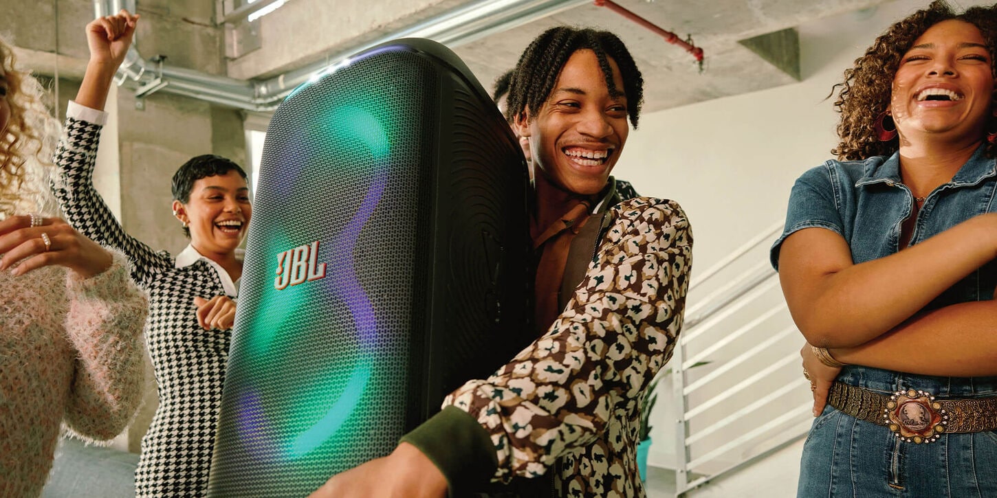 Friends holding a party speaker