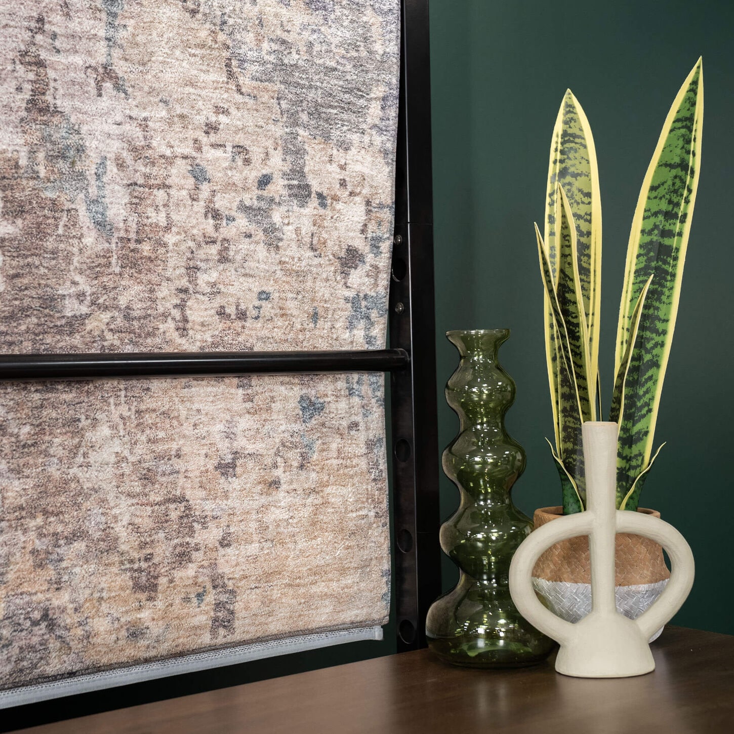Plant and vases sitting on top of the credenza in a living room with hanging rugs