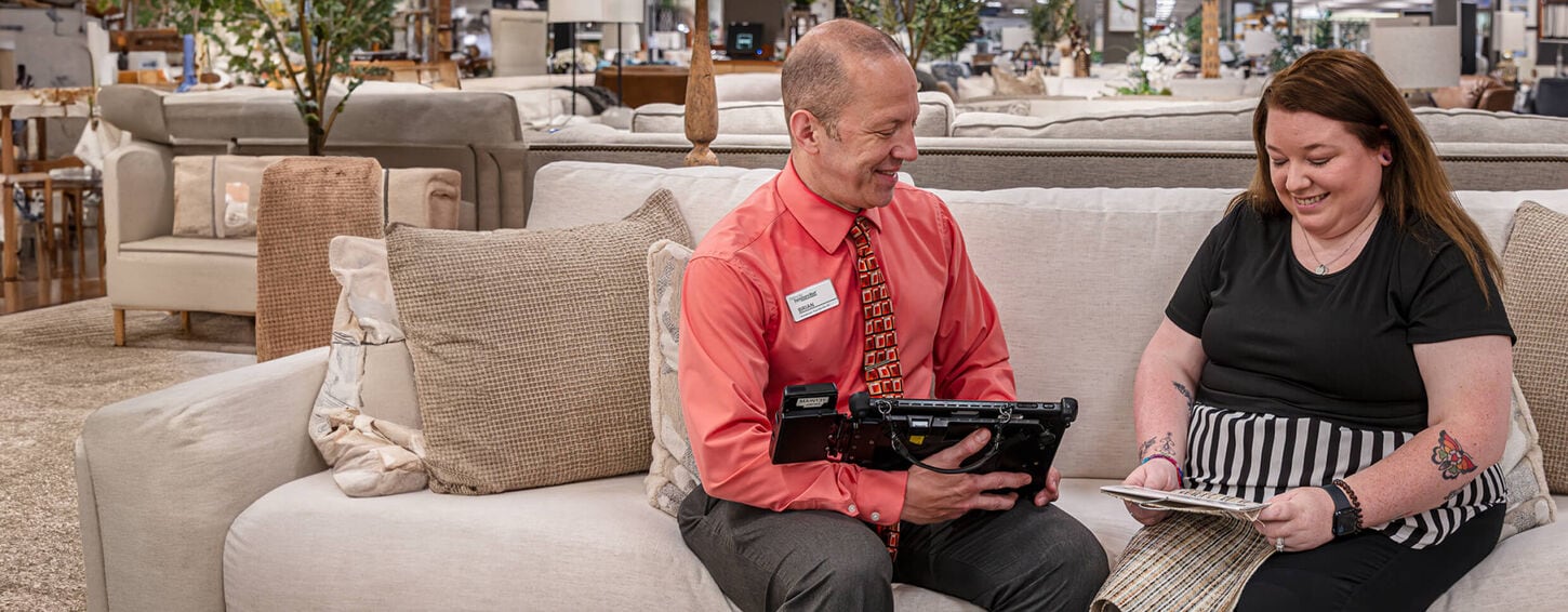 A sales expert sitting down with a customer discussing options in-store