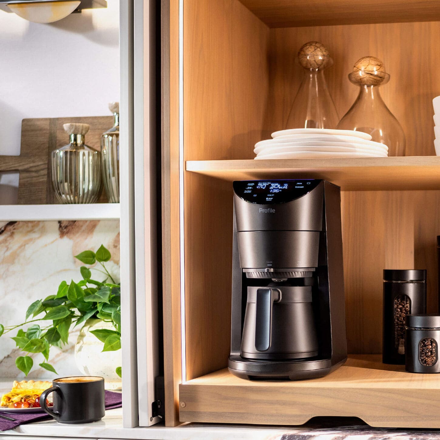 Coffee maker sitting on cabinet in kitchen with various kitchen items