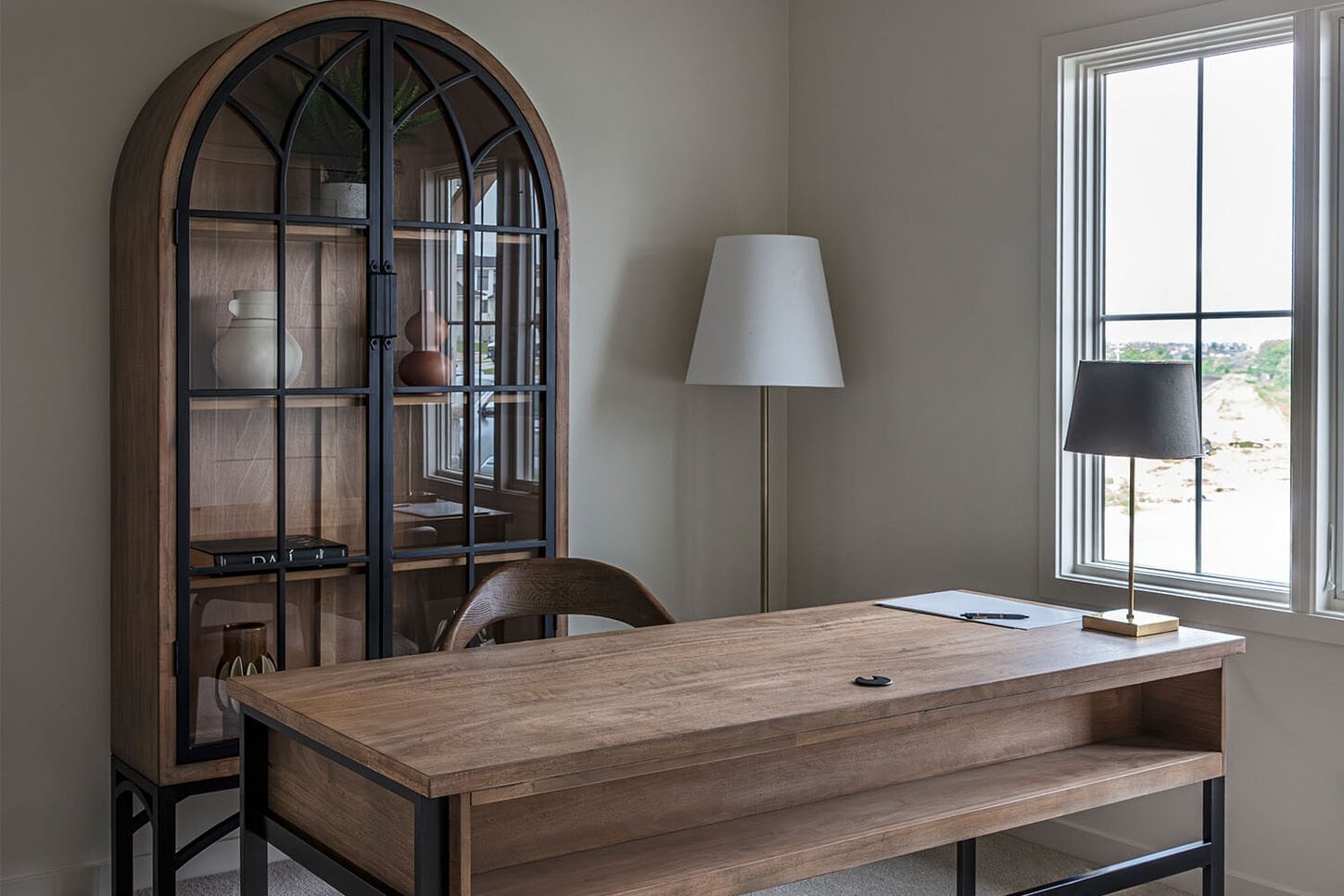 An office with a wooden desk and two tan chairs.
