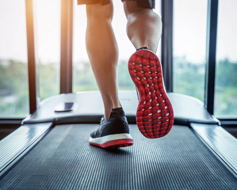 A closeup of a person walking on a treadmill