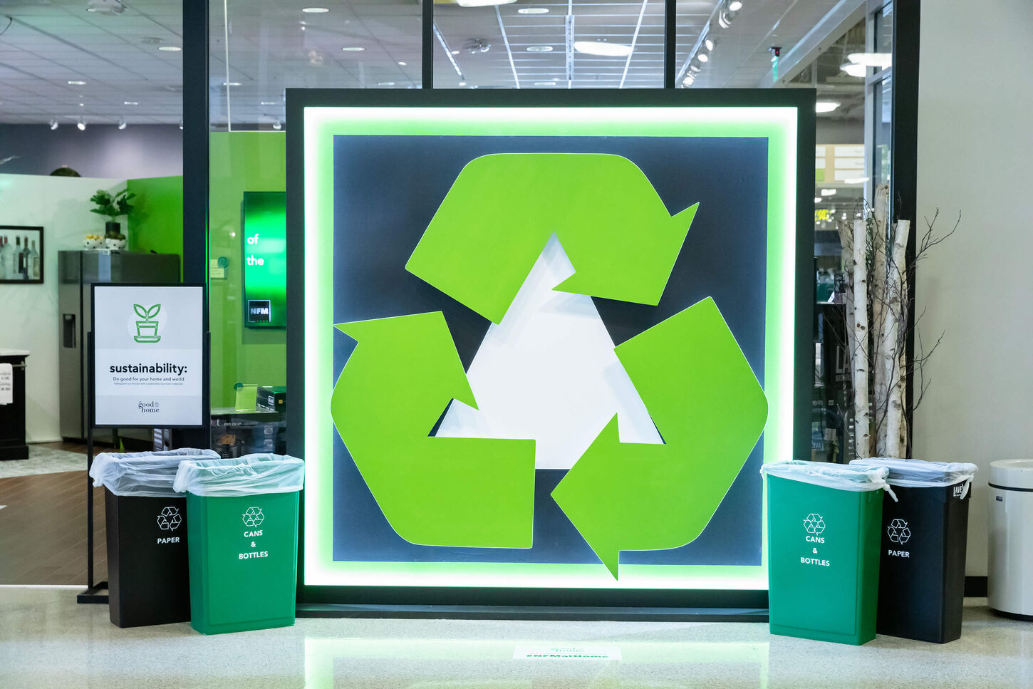 The good home pop up shop in TX showing a big green recycled sign with sustainability messaging.