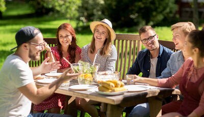 Group of friends enjoying meal together in backyard