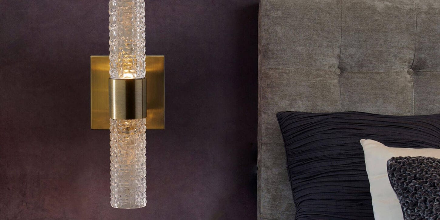 Lighting wall scone with gold accents in bedroom with purple walls to create moody look
