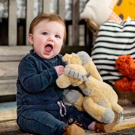 Baby smiling in bedroom with teddy bear