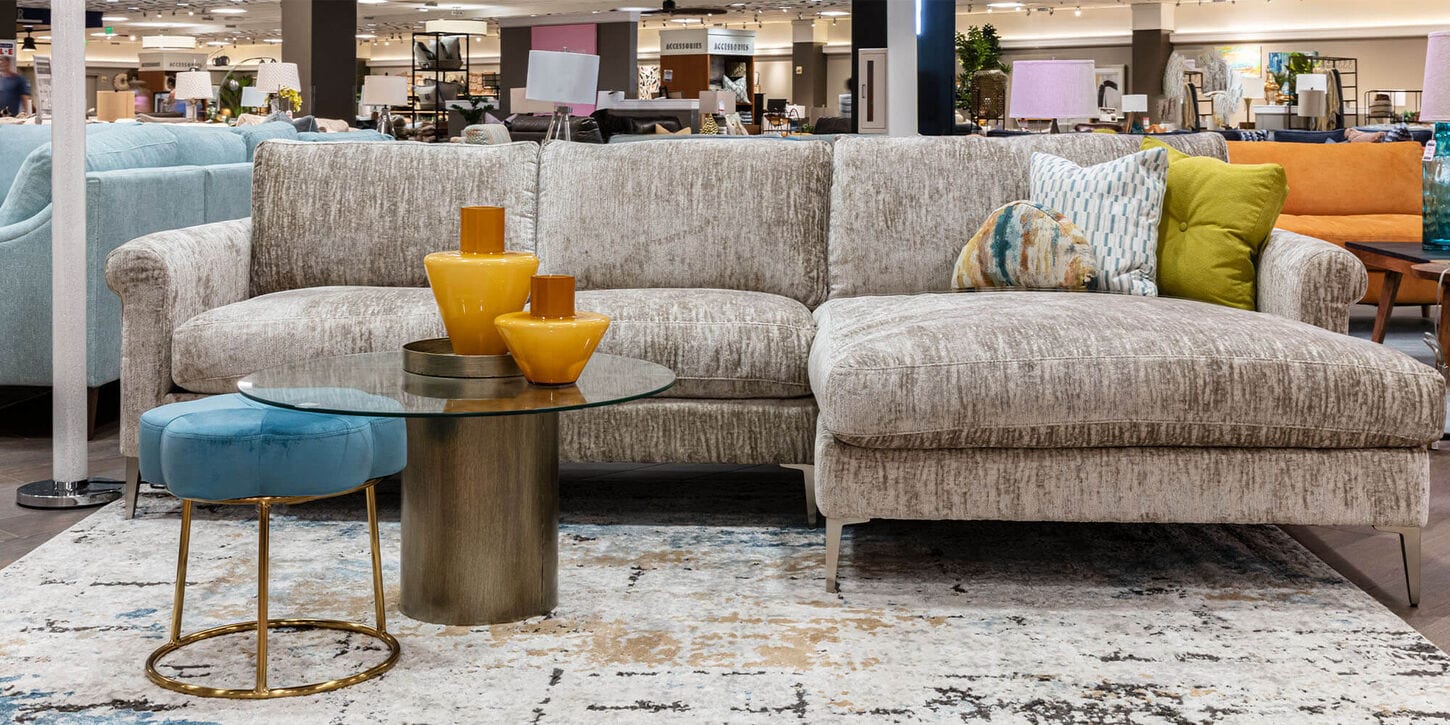 Custom couch designed by NFM in the Jonathan Louis Design Lab with a rug, coffee table and various other options in the background.