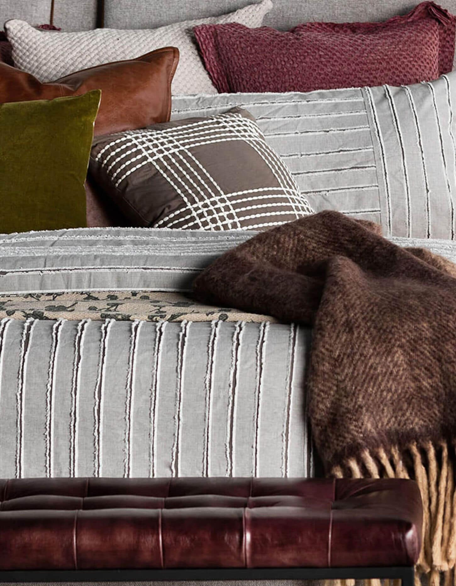 Bed with comforter, pillows, and a throw blanket.